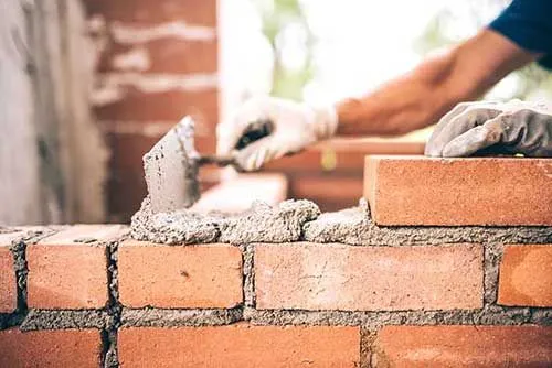 Masonry professional applying mortar to a brick wall